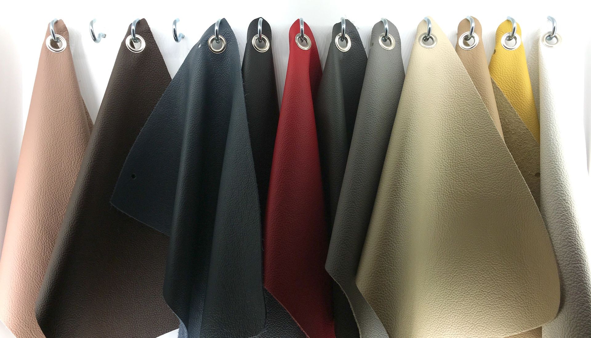 Leather colour and texture fabric swatches hanging on hooks. 